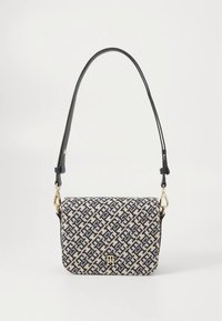 Cream and navy patterned fabric handbag with a flap closure, gold hardware, and a black leather shoulder strap. Dimensions and details not specified.
