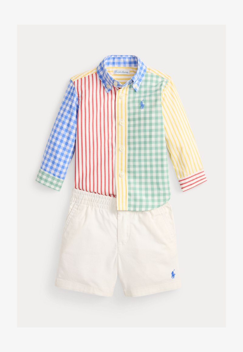 Παιδικό πουκάμισο με μακριά μανίκια σε πατς εργασίας, με κόκκινες, μπλε, πράσινες και κίτρινες ρίγες και καρό, συνδυασμένο με λευκές βερμούδες με ελαστική μέση.