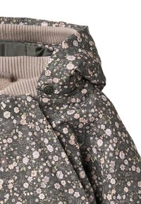 Kukkakuvioitu, tummanharmaa tikattu takki, jossa on vaaleanpunaisia ja vihreitä kukkakuoseja. Varustettu mukavalla beigenvärisellä neulotulla kauluksella ja painonappikiinnityksellä.