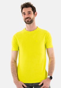T-shirt à manches courtes, col rond, de couleur jaune vif, en tissu doux avec une finition texturée ; présente un petit détail de logo discret.