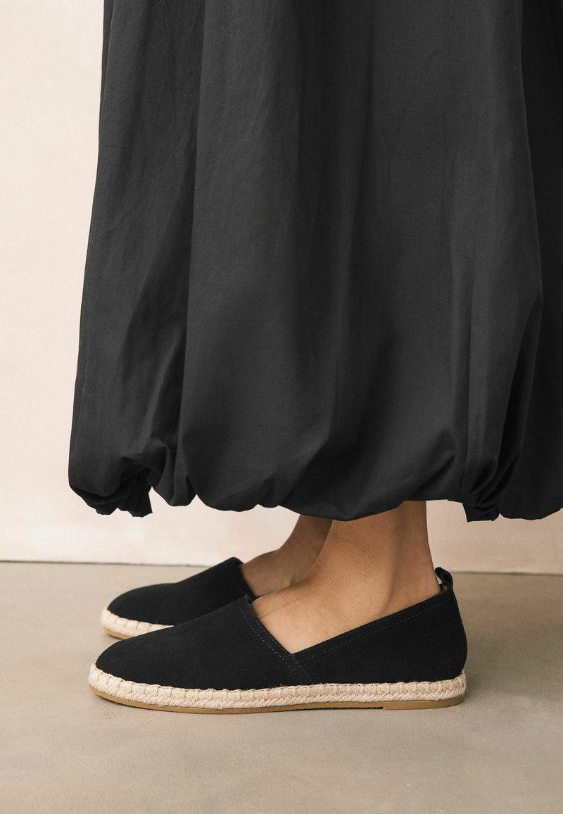 Mustat kangas espadrillot, joissa on punottu juuttipohja ja kumipohja. Mallissa on matala leikkaus ja pieni korko mukavuutta varten.