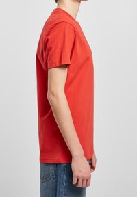 Korte mouwen T-shirt van felrode katoen, met een klassieke ronde hals en een relaxte pasvorm. Zichtbaar stiksel en een gladde textuur.