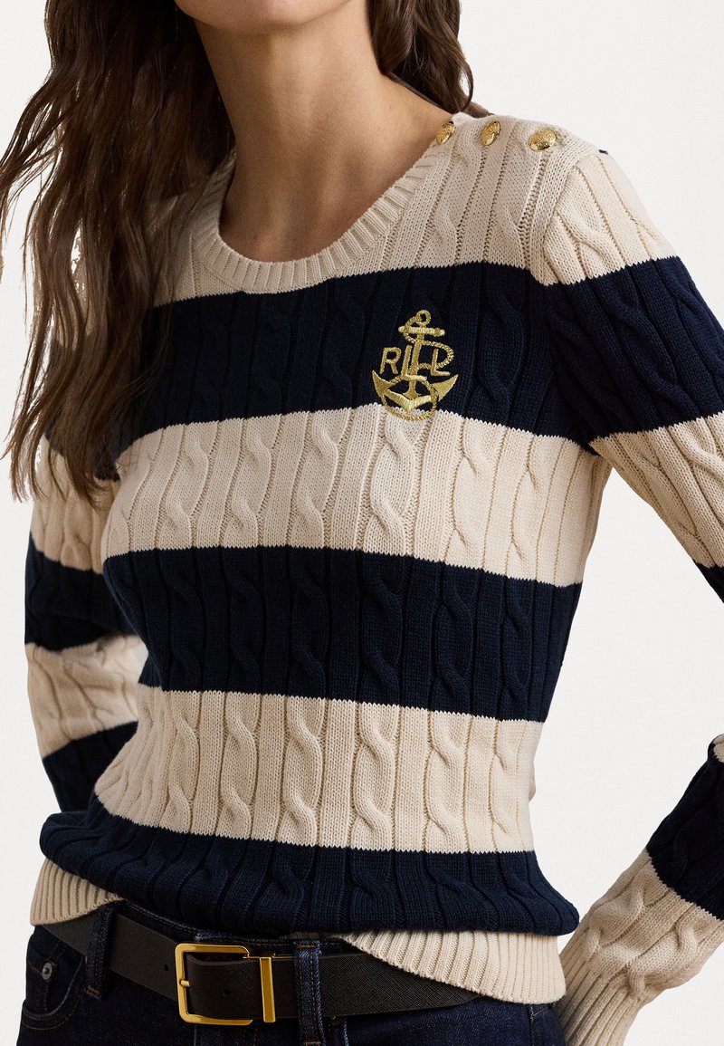 Dunkelblau- und cremefarbener gestreifter Kabelstrickpullover mit goldenen Knöpfen an der Schulter und einem gestickten Ankerlogo auf der Brust.
