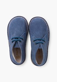 Pantofi din piele întunecată, cu vârf rotund și șireturi bleumarin, având o broderie bej pe margini și o suprafață moale, texturată.