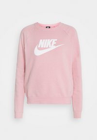 Růžová mikina z měkké látky s bílým logem Nike uprostřed. Má kulatý výstřih a žebrované manžety.