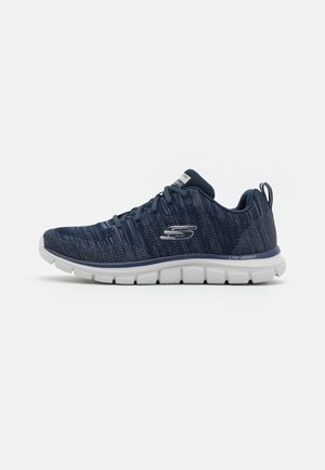 Zapatilla deportiva azul marino con parte superior de malla texturizada, suela blanca ligera y detalle del logo plateado en el lateral.