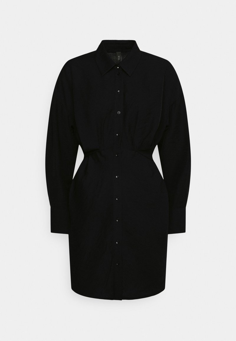 Czarna sukienka koszulowa z długim rękawem, kołnierzykiem, zapinana na guziki z przodu, dopasowana w talii, sięgająca do połowy uda, na jasnym, gładkim tle.