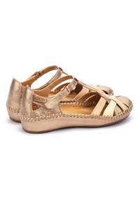 Gouden leren sandalen met meerdere straps en een geweven detail langs de rand. Soepele textuur met een ronde neus en verstelbare sluiting.