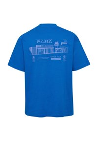 Niebieska koszulka z jasnoniebieską grafiką fasady stadionu przedstawiającą wejścia, salon oraz tekst zawierający "Park Stadium" i instrukcje dotyczące miejsc siedzących.