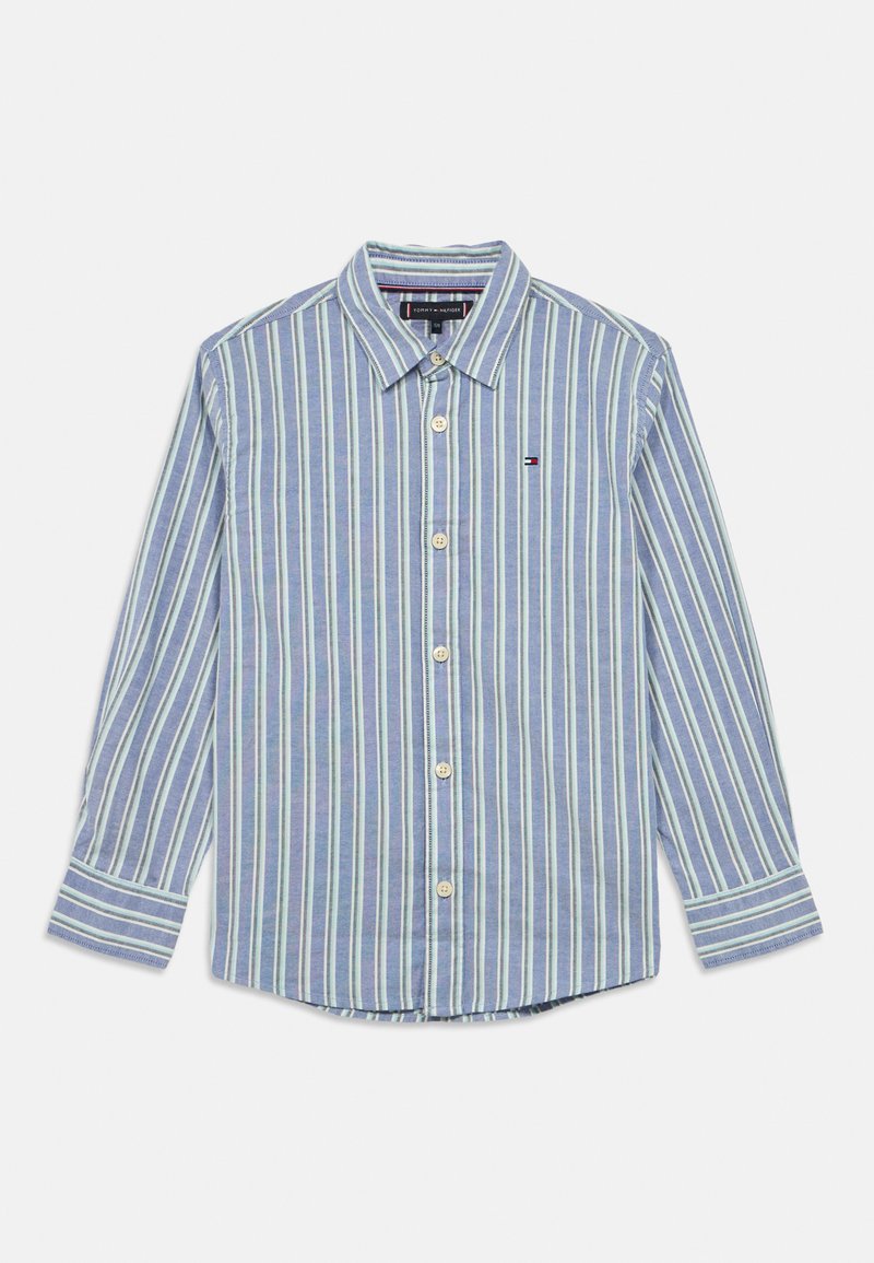 Srajca z gumbi v modri barvi z navpičnimi črtami v zeleni in beli barvi. Ima koničast ovratnik, dolge rokave in ukrivljen rob z logotipnimi aplikacijami.