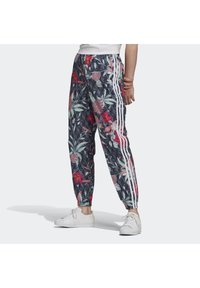 Mönstrade joggingbyxor i mörkblått med livfulla rosa och gröna detaljer. Har tre vita sidostripes och elastiska muddar.