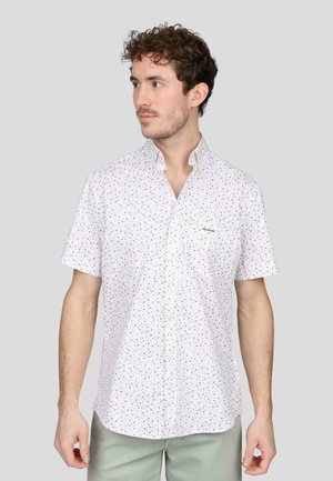Chemise blanche à manches courtes avec un motif floral rose et vert. Dotée d'un col boutonné et d'une poche poitrine. Tissu léger.