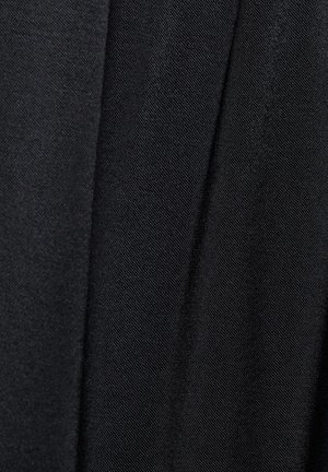 Czarna tkanina o gładkiej fakturze, z subtelnym wzorem tkania. Obraz przedstawia nakładające się na siebie fragmenty ukazujące głębię i fałdy.