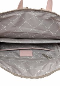 Interno grigio chiaro di una borsa a mano con un motivo a diamante e cerchi. Due scompartimenti e una sezione con zip, con un'etichetta rosa.
