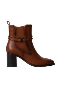 Bottine en cuir marron avec talon bloc, bride décorative et boucle autour de la cheville, et languettes de tirage à l'avant et à l'arrière.