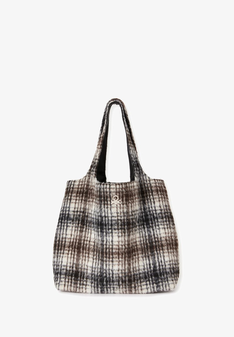 Károvaná taška s měkkým, texturovaným povrchem v hnědé, černé a krémové barvě. Obsahuje dva dlouhé popruhy a dekorativní emblém.