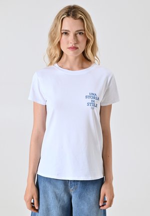 T-shirt bianca in cotone con maniche corte, caratterizzata da una stampa blu con il testo "UNA STORIA DI STILE" sulla parte sinistra del petto.
