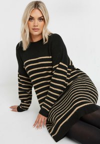 Mustassa ja beige raidallinen neulemekko, jossa on pitkät hihat, rento malli, pyöreä pääntie ja teksturoitu kangas, jossa on vaakaraidat koko mekossa.