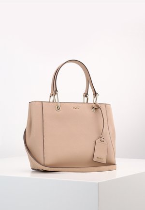 Bolso de mano beige de cuero con dos asas y una correa de hombro desmontable, con una etiqueta a juego y herrajes dorados, sobre una superficie blanca.