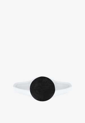 Bague en argent avec un bandeau lisse et poli. Présente une pierre noire ronde sur le dessus, offrant un design minimaliste et moderne.