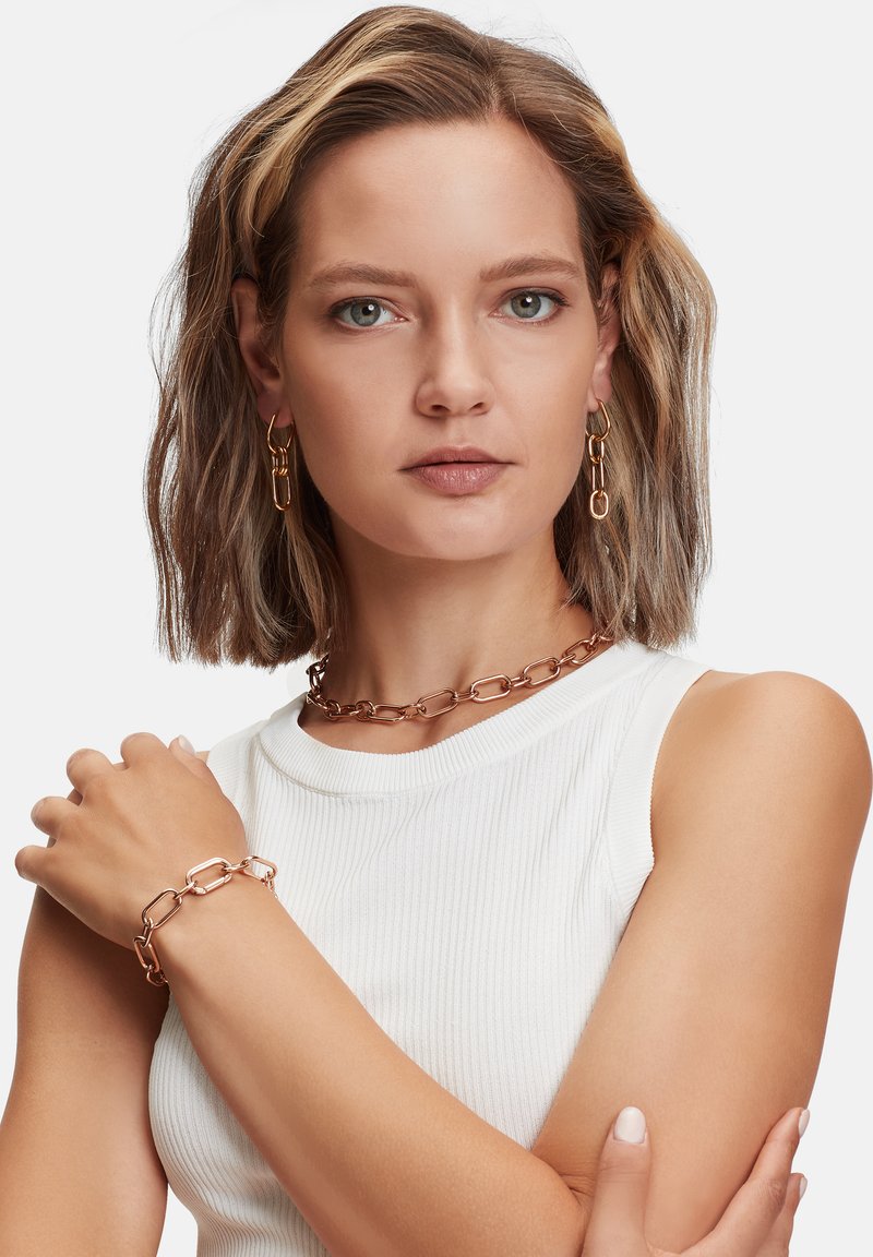 Roze gouden kettingjuwelen, met grote, langwerpige schakels in een gladde afwerking. Inclusief bijpassende oorbellen en een armband.