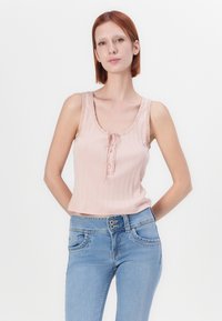 Ροζ ριγωτό απλό τοπ με φαρδύ λαιμόκοψη, διακοσμητικά κουμπιά και κυματιστές άκρες, συνδυασμένο με ανοιχτό μπλε εφαρμοστά τζιν.