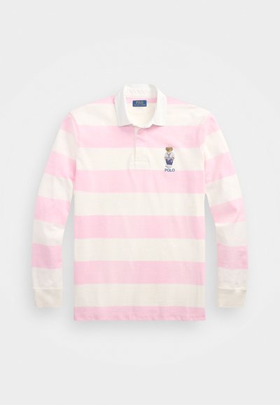 Ilga rankovė polo marškinėliai, turintys rožinių ir baltų horizontalių juostelių, pagaminti iš medvilnės, su apykakle ir išsiuvinėtu logotipu ant krūtinės.