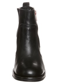 Botines de cuero negro que presentan una punta redondeada, costuras sutiles y una cremallera lateral para el cierre. Textura suave con un tacón bajo.
