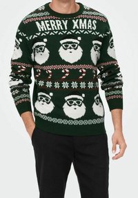Grüner Strickpullover mit weißen Weihnachtsmann-Gesichtern mit Brille, Zuckerstangen, Schneeflocken und dem Text "FROHE WEIHNACHTEN" in einem festlichen Muster.