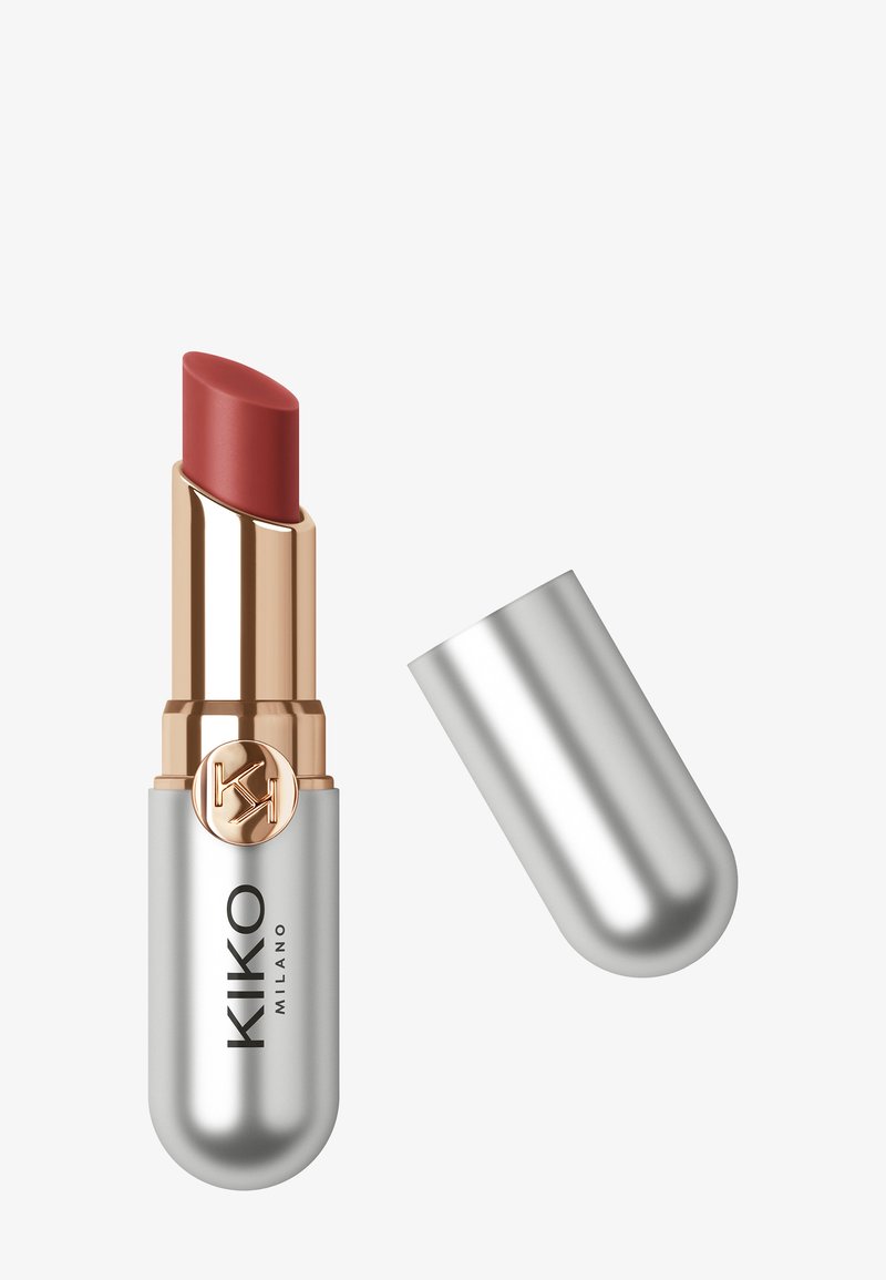 Rossetto in un astuccio metallico argento, con un accento in rosa oro e una tonalità cremosa di mauve. Il tappo è parzialmente rimosso, rivelando il bullet.