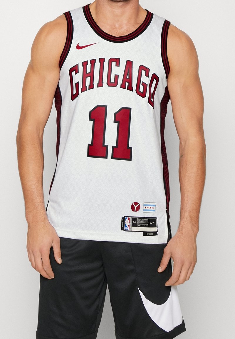 Biała koszulka koszykarska z czerwonymi akcentami, z wyraźnym napisem "CHICAGO" i numerem "11", tekstura w wzory, logo Nike i metki NBA na dolnej krawędzi.