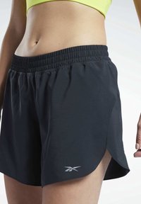 Černé sportovní kraťasy z lehké látky s elastickým pasem, bočními rozparky a malým logem na lemu.