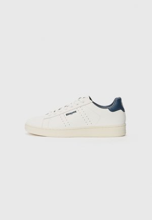 Baskets basses blanches avec languette de talon bleu marine, panneaux latéraux perforés, semelle beige et logo Blauer sur le côté extérieur.