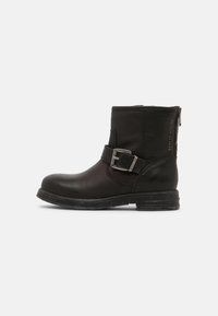 Botas de tornozelo em couro preto com fecho de correr lateral, detalhe de fivela, biqueira redonda e sola de borracha texturizada. Design simples e elegante com acabamentos mínimos.