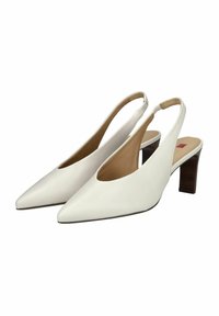 Décolleté bianchi con cinturino alla caviglia, punta affusolata, tomaia in pelle liscia e tacco a blocco in legno di media altezza. Presentano un design con ritagli e una soletta beige.