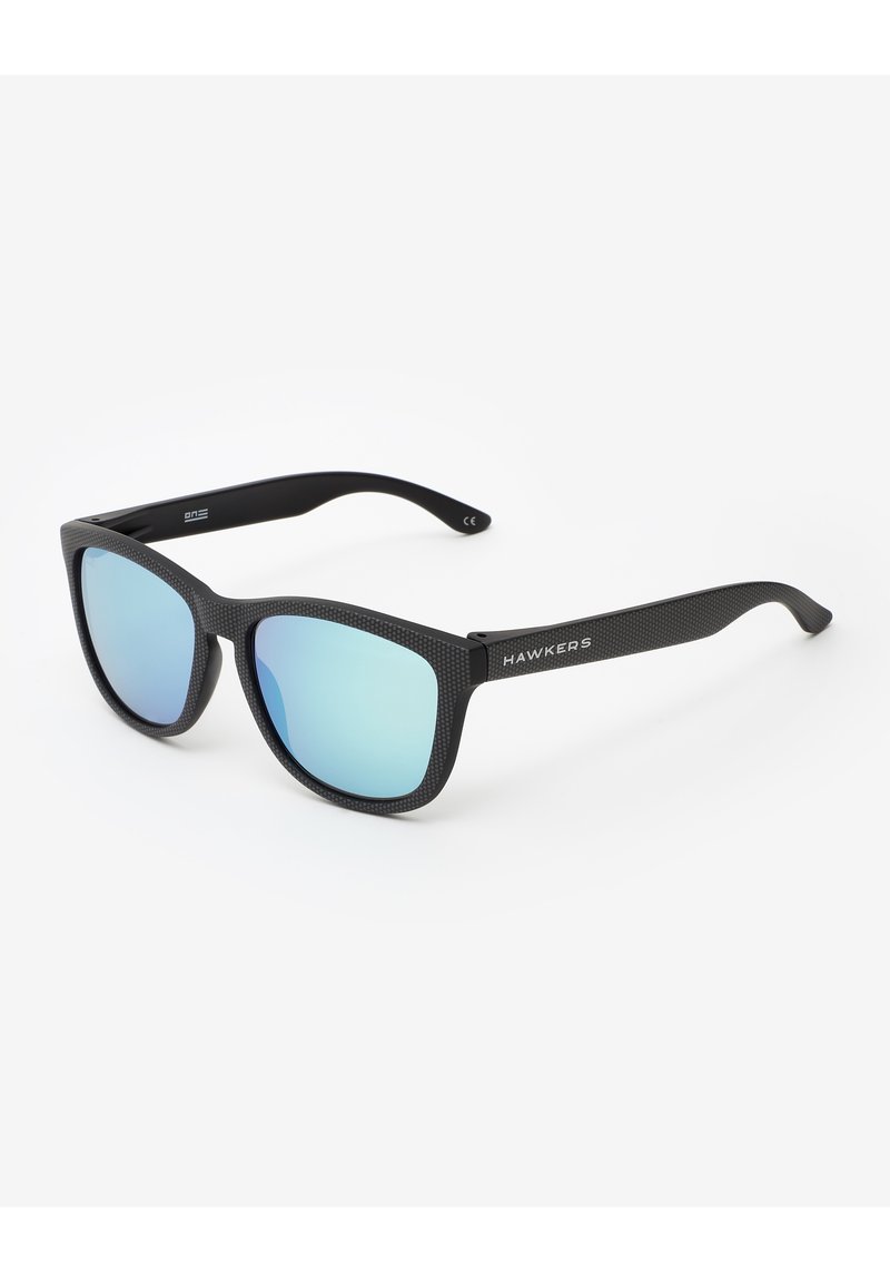 Ochelari de soare negri cu un cadru texturat, lentile albastre cu oglindire și logo-ul "HAWKERS" pe lateral. Design unghiular cu brațe drepte.