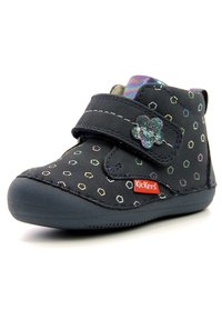 Black ankle boot with multicolored hexagonal patterns, fabric upper, velcro strap, rubber sole, and floral accent near strap.