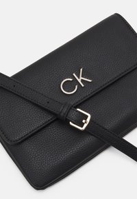 Calvin Klein RELOCK CROSSBODY BAG - Umhängetasche - black