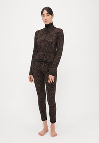 Čierne a hnedé leopardie tričko s vysokým golierom a zodpovedajúcimi legínami, vyrobené z pružnej látky, s elastickým pásom s logom značky.