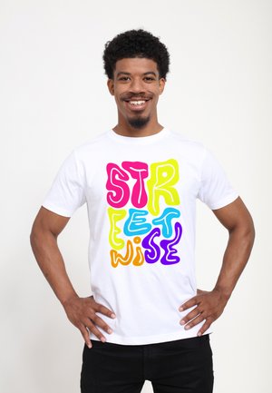 Hvid bomulds T-shirt med fed, flerfarvet tekst "STREETWISE" i et legende skrifttype. Korte ærmer og rund halsudskæring.