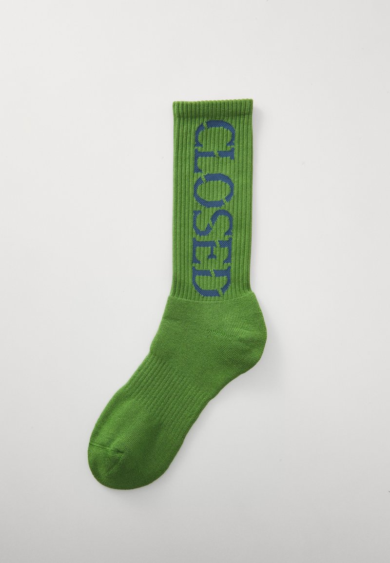 Zöld crew zokni bordás textúrával, az oldalán nagy kék "CLOSED" felirattal. Sima pamut anyag. Megerősített lábujj rész.