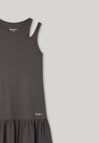 Pilkas be rankovių suknelė su briaunotu paviršiumi, plečiasi apačioje, su baltu "Pepe Jeans" logotipu. Paprastas, laisvas fasonas.