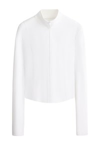 Veste blanche à manches longues avec fermeture éclair à l'avant et coupe courte et ajustée, présentée sur fond blanc uni.