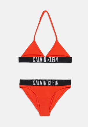 Bikini deux pièces orange vif avec des bandes élastiques noires affichant la marque blanche « Calvin Klein » en haut et en bas.