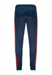 Pantaloni sportivi navy con strisce laterali rosse e gialle, vita elasticizzata, cerniere alla caviglia e una piccola tasca sul retro con zip.
