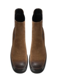 Stivali alla caviglia in suede marrone con punta liscia e arrotondata e pannelli elastici sui lati. Suola in gomma nera che aggiunge contrasto e durata.