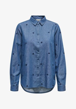 Camicia di jeans con colletto button-down, maniche lunghe e ricamo a forma di cuore blu navy su sfondo azzurro chiaro. Orlo sagomato.
