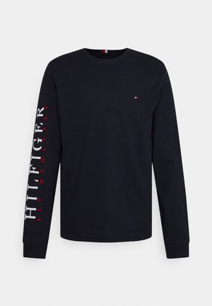 Schwarzes langärmliges T-Shirt aus Baumwolle. Verfügt über einen abgerundeten Ausschnitt, gerippte Bündchen und eine rote und weiße Textdetail auf dem rechten Ärmel.