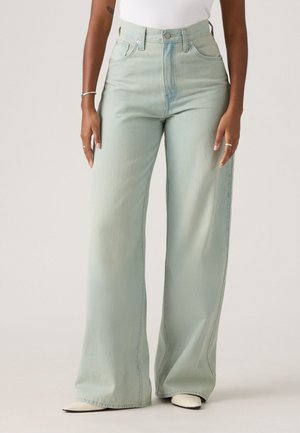 Light green high-waisted wide-leg jeans made of soft denim. Features belt loops, front pockets, and subtle fading. Smooth texture.