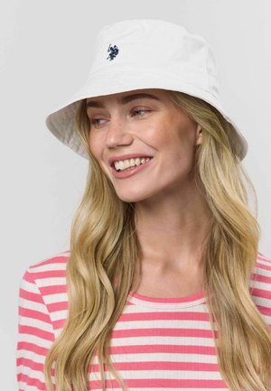 Hvid bøllehat lavet af bomuld, med et mørkeblåt broderet logo på forsiden. Skyggen er bred med en klassisk rund form.